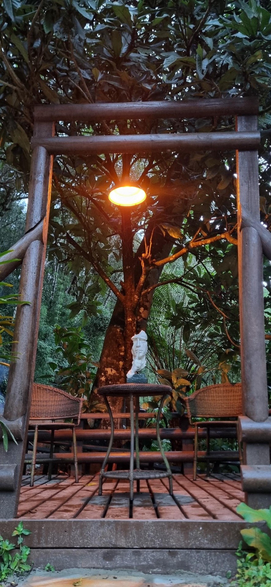 Pórtico de madeira no jardim do Mauna Floresta ao entardecer