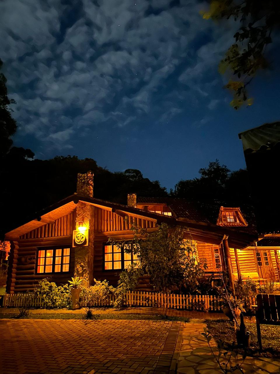 Casa de troncos do Mauna Floresta sob o céu noturno